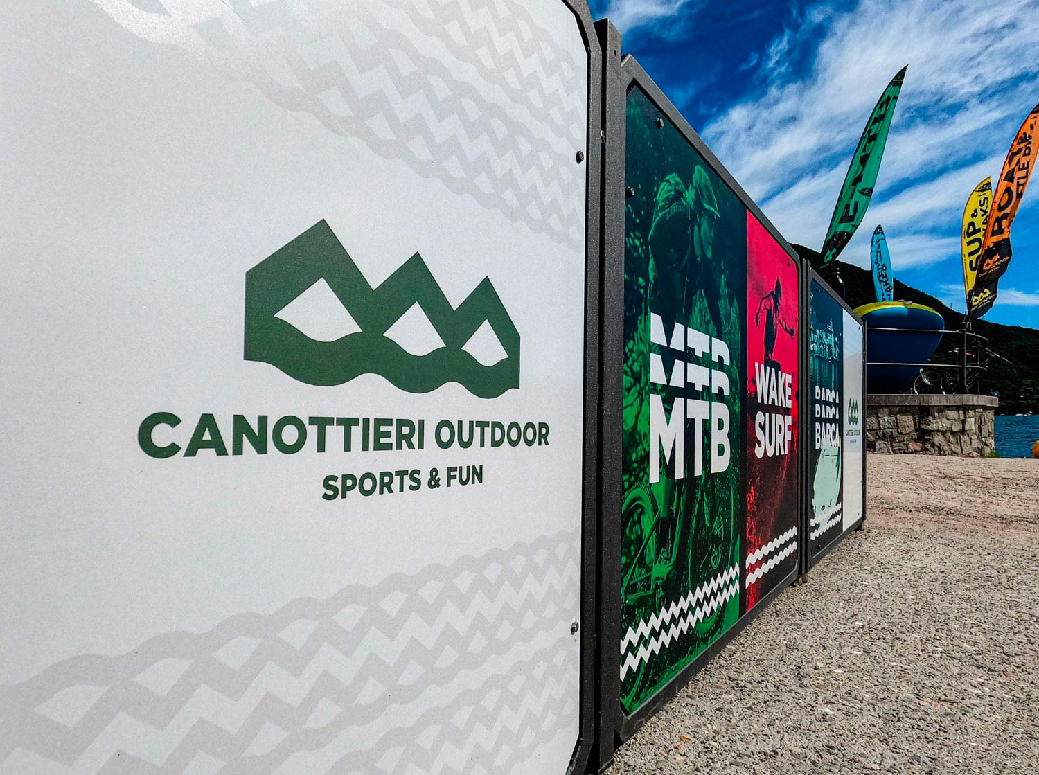 Logo e brand identity di Canottieri Outdoor Omegna realizzato da SEBA! grafico di Gravellona Toce nel VCO del bancone della reception con dei pannelli colorati